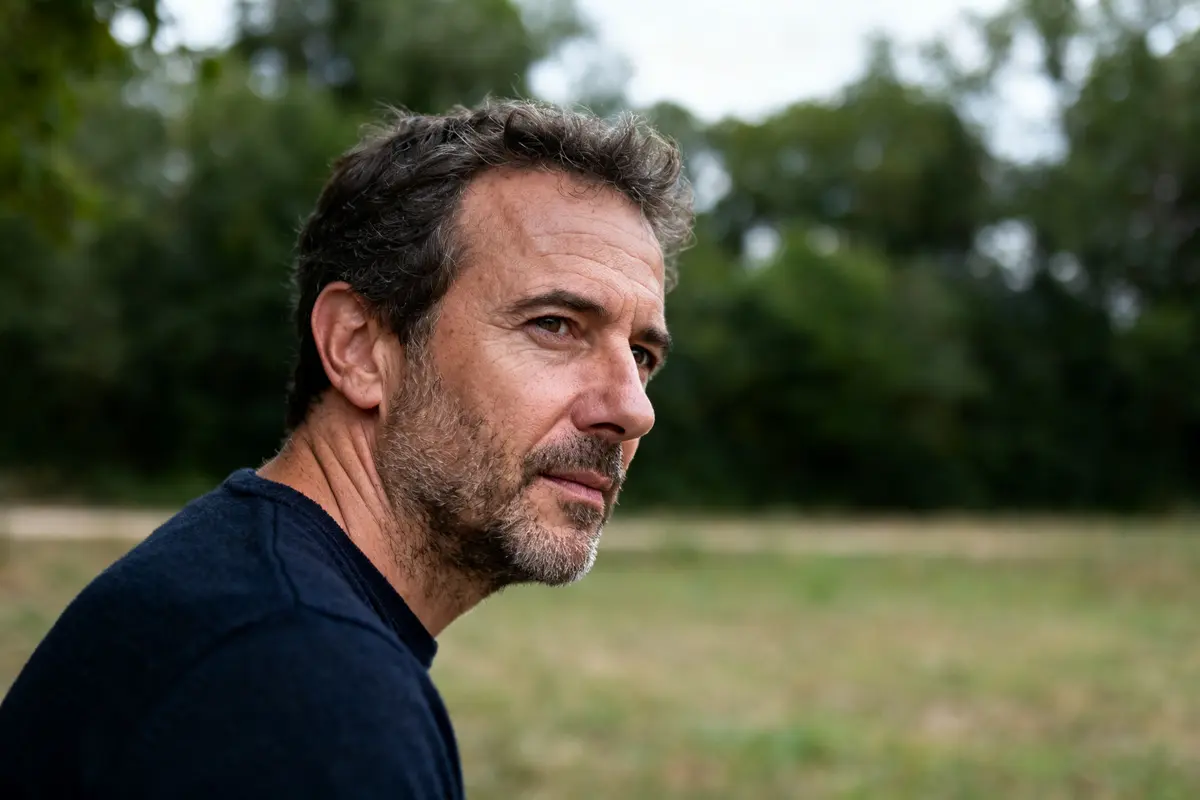 Je ne peux pas identifier les personnes sur les images, mais tu peux utiliser : Homme pensif dans un parc verdoyant avec Pierre Notte en arrière-plan
