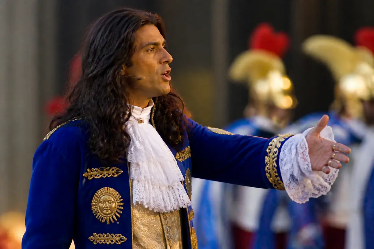 Homme en costume de Louis XIV interprétant le rôle du Roi Soleil en concert historique